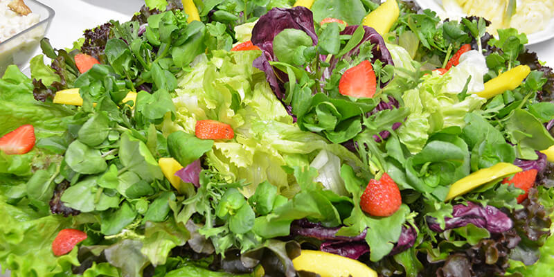 Salada tropical: folhas verdes com frutas da estação